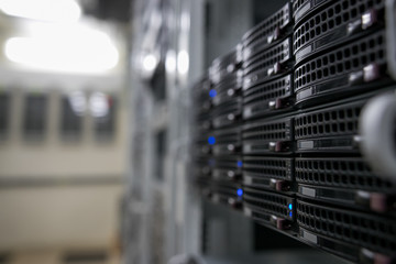 Computer Server mount on rack in data center room with red lighting alarm.