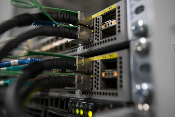 Server rack with red internet patch cord cables connected to patch panel in server room