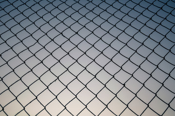 Old metal mesh against the evening sky. Abstract background	