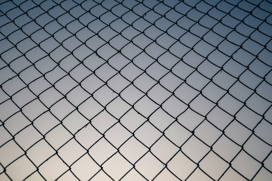 Old metal mesh against the evening sky. Abstract background	