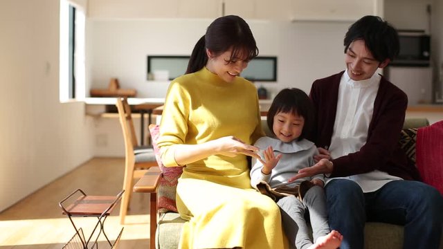 Parents playing rock-paper-scissors with daughter