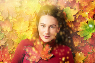 Naklejka na ściany i meble Girl holding red maple leaf in hand over colorful fallen leaves background. Gold cozy autumn concept. Top view. Copy space for advertising. Sunny day, warm autumn weather.