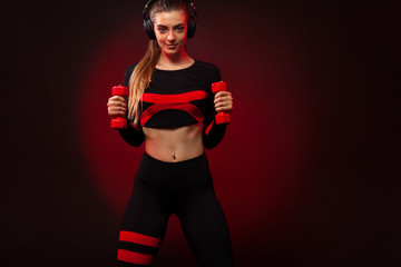 Sporty fit woman, athlete with dumbbells makes fitness exercising on red background. Fitness and workour motivation.