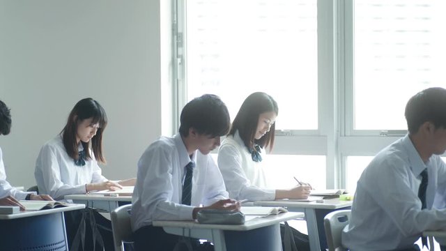 Group of high school students studying in classroom