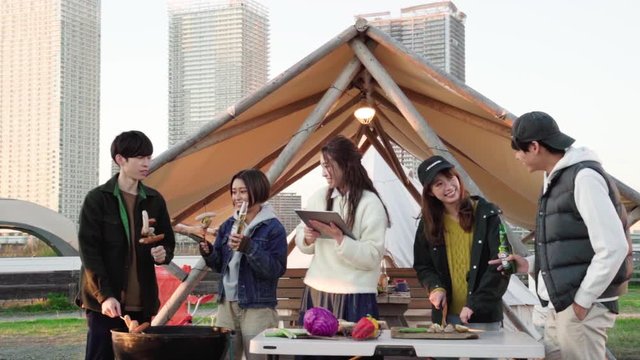Group of friends having barbecue while camping