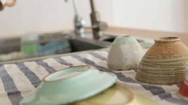 Hand of woman washing dishes in kitchen
