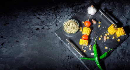 Fresh yellow maize. Raw organic sweet corn cobs on black table. Top view with copy space