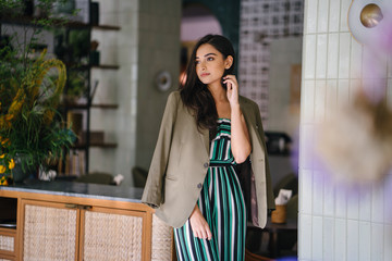 Portrait of a tall, slim, elegant and beautiful Indian Asian woman in an elegant jumper with a...