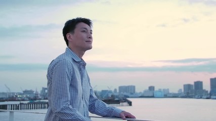 Man walking on terrace in city at sunset