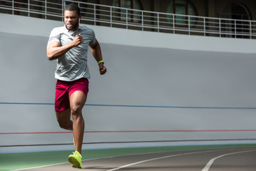 Active bearded young male athlete at the stadium