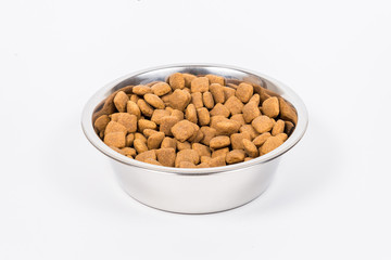 Silver Cup with pet food pieces isolated on white background. Metal food bowl for cat or dog. Proper feeding of dry pet food. Copy space