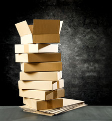 Boxes in a pile on a table top on a black wall background. Some parcel to send.