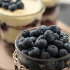closeup of blueberries in glass with  tiramisu on background