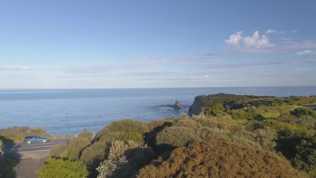 4k aerial footage along winding coastal road and countryside.