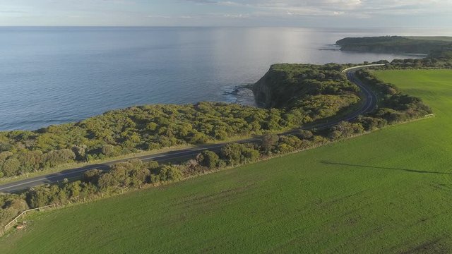 4k aerial footage along winding coastal road and countryside.