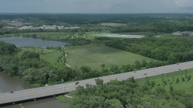 Stationary drone shot of an American highway in the midwest with a river in the background in the summer.  in 4K.