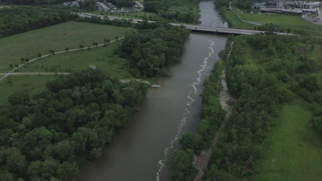 Drone flies over a river towards a lone highway in the Midwestern USA, in summer in 4K.