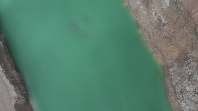 Drone flyover weird green quarry pool in the Midwestern USA.  in summer, in 4K.