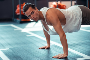 Serious well built man putting his hands on the floor