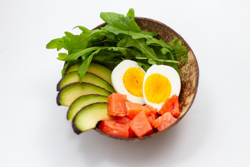 Soft-boiled eggs, avocado and red fish fillet in a plate