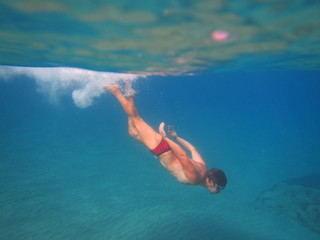 A young man swimming underwater in the sea