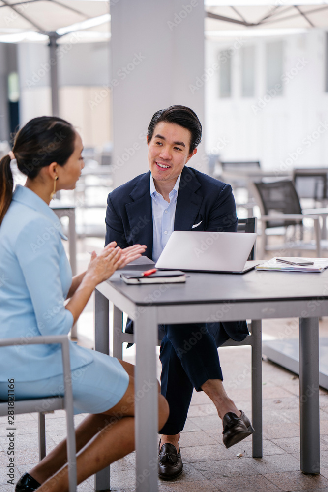 Wall mural a young, handsome and well-groomed asian man in a dark suit is interviewing a professional woman can