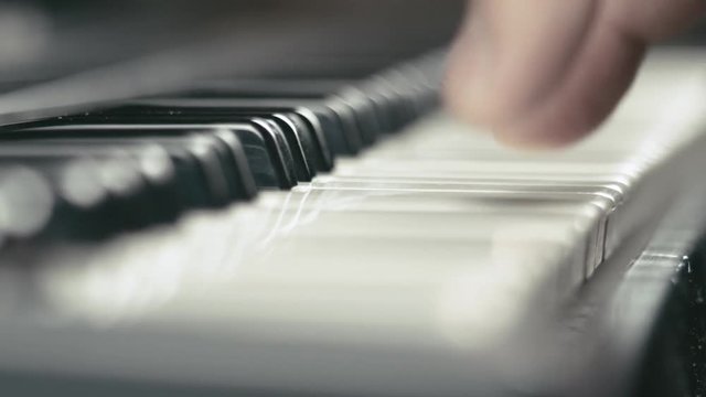 Macro shot of a musician's hands while he plays keyboards.