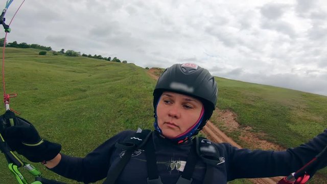 Woman is flying the paraplane close to the ground