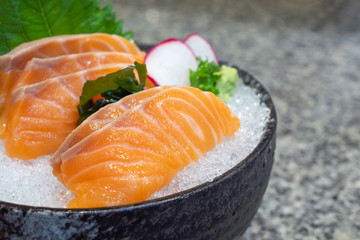 salmon sashimi on ice in black bowl japanese food