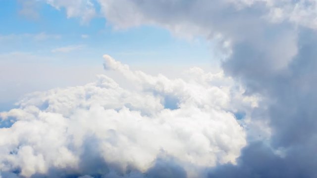 Flying through heavenly beautiful cloudscape. Picturesque timelapse of white fluffy clouds moving softly on the clear blue sky in pure sunshine. Direct view from the cockpit.