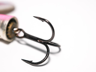 Close up / macro of a treble fishing hook attached to a lure.