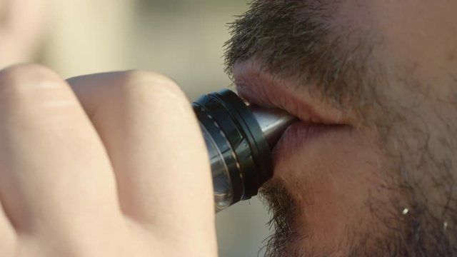 Closeup of a bearded Caucasian male vaping