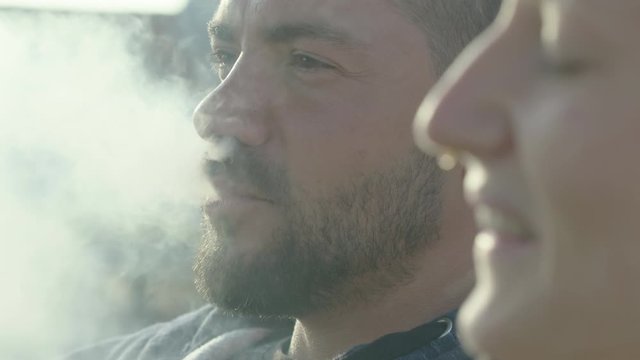 Attractive young couple vaping outdoors, 60 frames per second