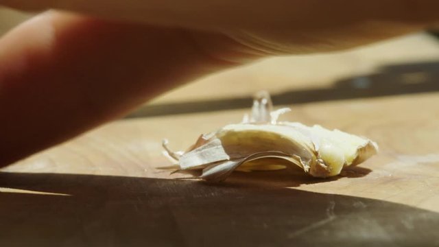 Crushing up a clove of garlic