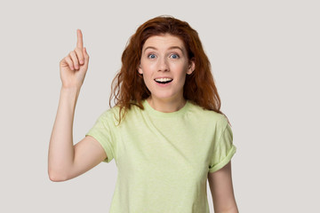 Red-headed woman point finger up find answer to question