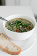 Zuppa Toscana Soup on Table with Bread, White Background
