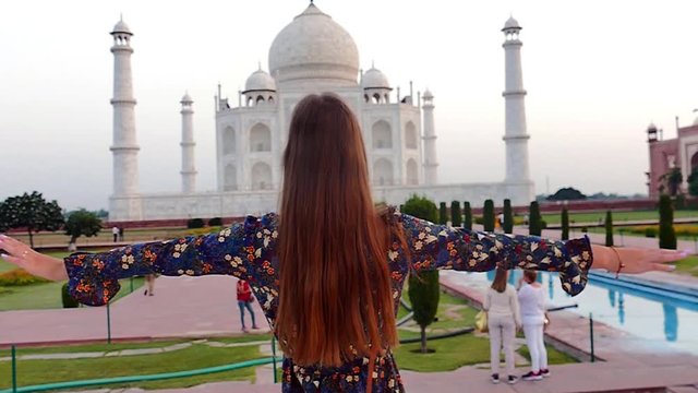 Slow motion (120 fps): beautiful young lady enjoying the beauty of Taj Mahal in Agra, India during the sunrise