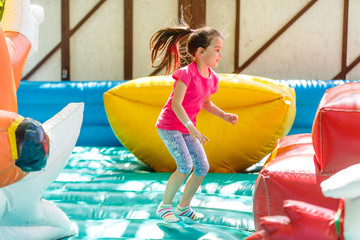 Joyful little girl playing on a trampoline