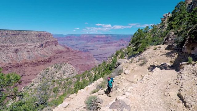 Hiker woman hiking in Grand Canyon. Healthy active lifestyle image of hiking young multiracial female hiker in Grand Canyon, Adventure and travel concept. Women hiking in USA national park.