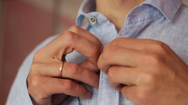 dress up for work,a blue shirt is put on by a man at work and buttoned