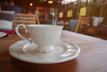 cup of coffee on wooden table in coffee shop