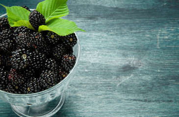Fresh blackberry. Juicy blackberry in a bowl on a wooden table. View from above. Copy space. Harvest concept