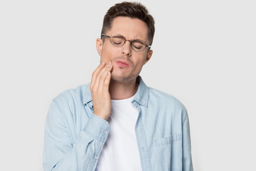 Headshot studio portrait man in glasses suffers from tooth ache