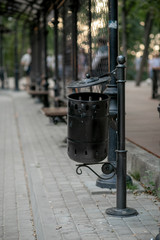 Fototapeta na wymiar forged black trash can on the street in the Park adorns the city