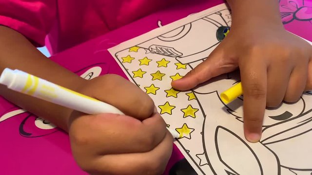 Kid coloring on character with markers