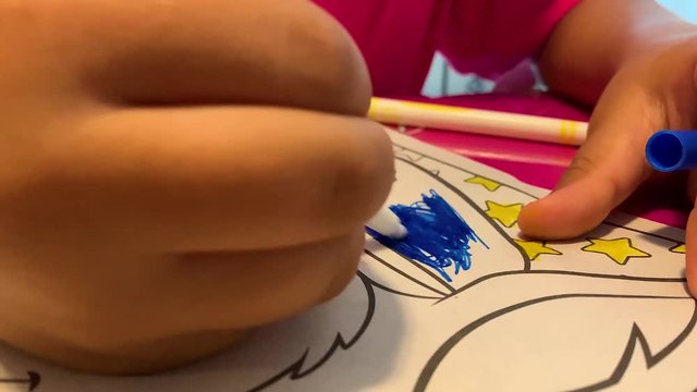 Kid coloring on character with markers