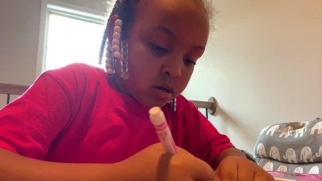 Kid coloring on character with markers