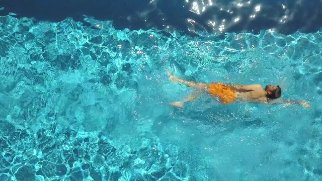Man swimming in pool at holiday resort, birds eye view