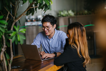 A pair of diverse team mates have a business meeting and discussion together to collaborate. A...