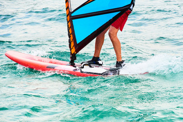 Windsurfing details. A windsurfer rides on the sea